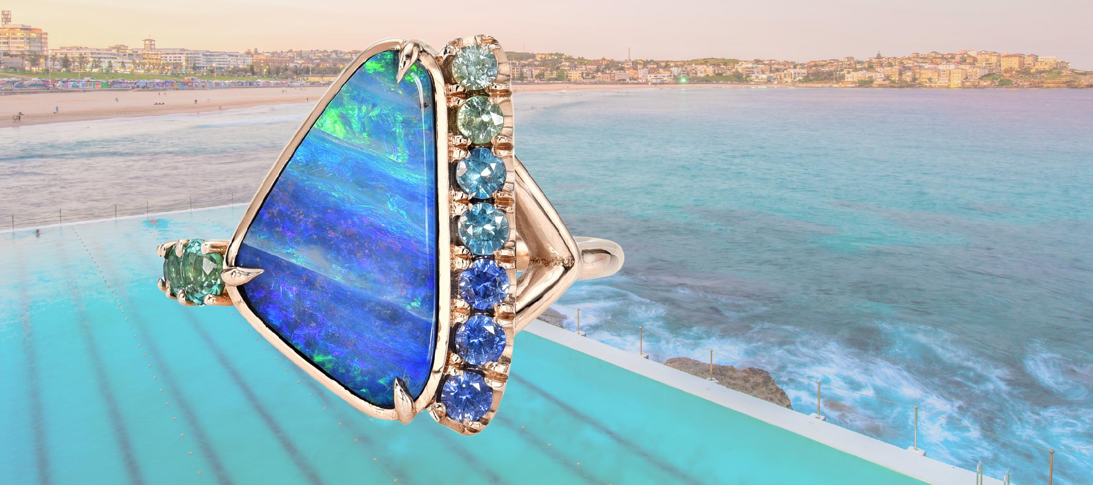 An Australian Opal Ring by NIXIN Jewelry in rose gold with sapphires and emeralds.