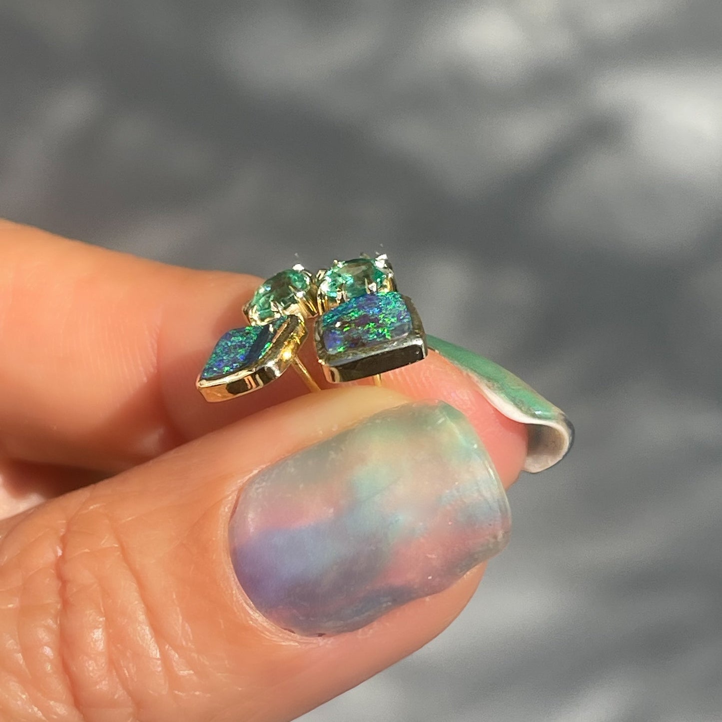 Angled shot of Australian Opal Earrings by NIXIN Jewelry. Shows the bezel setting around the opals.