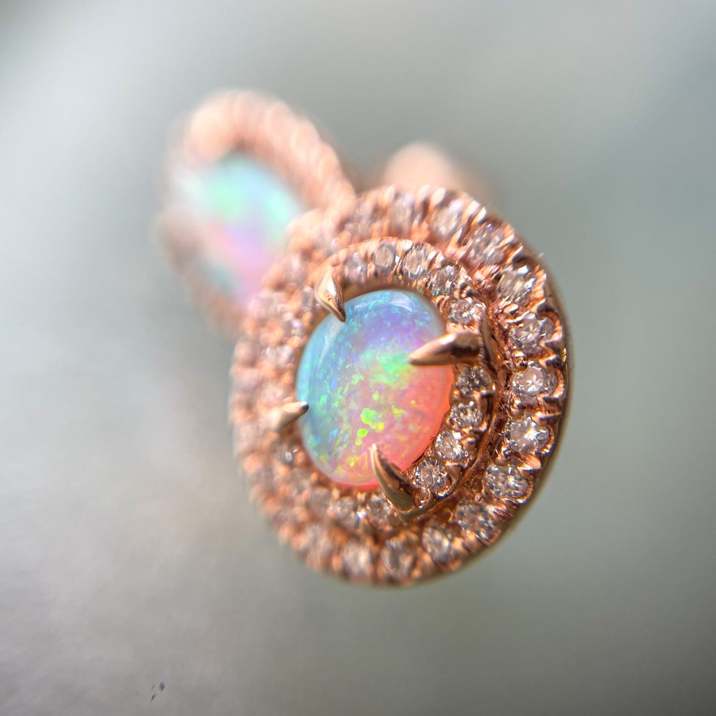 A close up shot of Australian Opal Earrings by NIXIN Jewelry with crystal opals and diamonds.