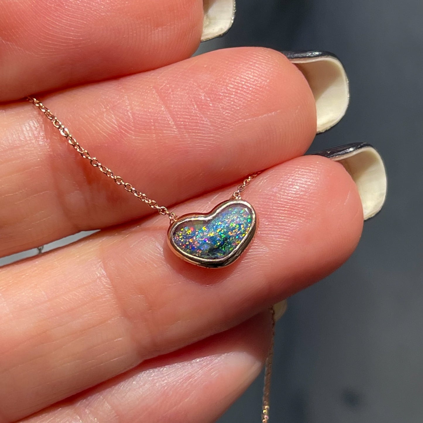 An Australian Opal Necklace by NIXIN Jewelry. The heart necklace has a dainty opal pendant.