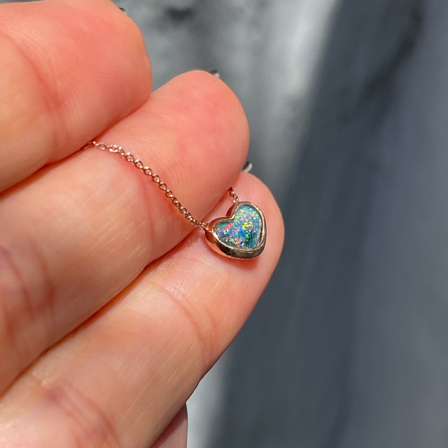 Angled shot of an Australian Opal Necklace by NIXIN Jewelry. Shows the Black Opal in a bezel setting.