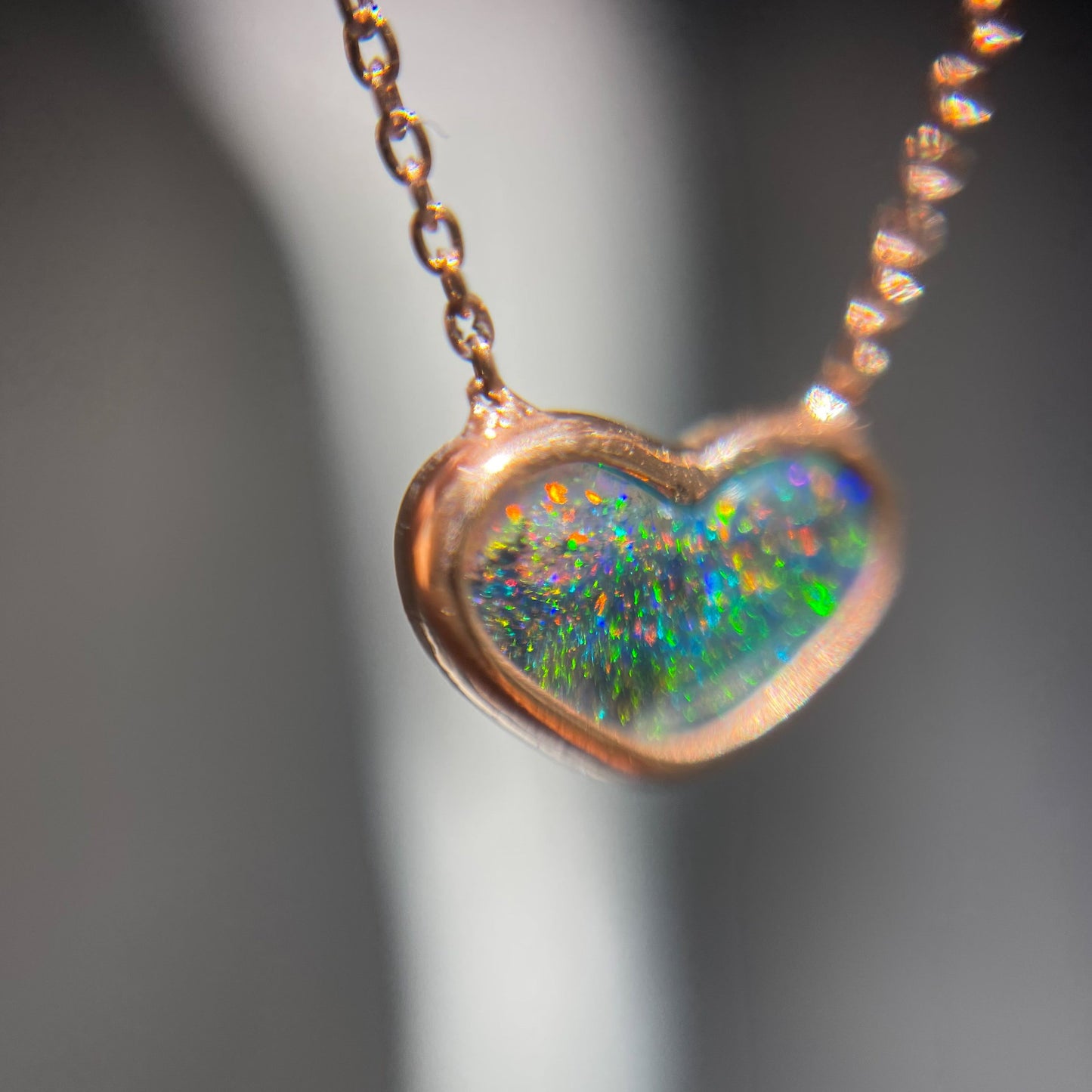 Close up of an Australian Opal Necklace by NIXIN Jewelry. Shows a Black Opal in a bezel setting.