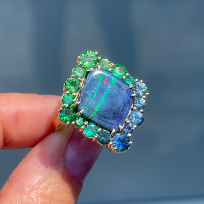 An Australian Opal Ring by NIXIN Jewelry. An emerald and opal ring with sapphires and tsavorite garnets.