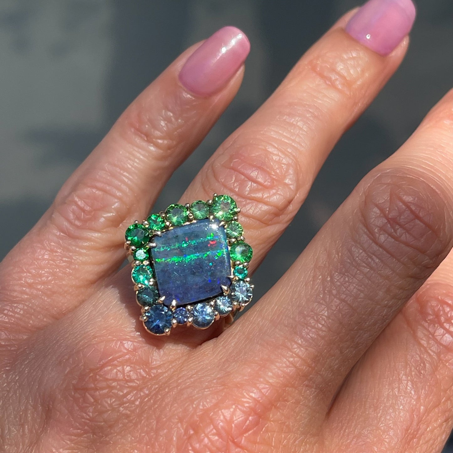 An Australian Opal Ring by NIXIN Jewelry. A Boulder Opal ring with a halo of precious gemstones.