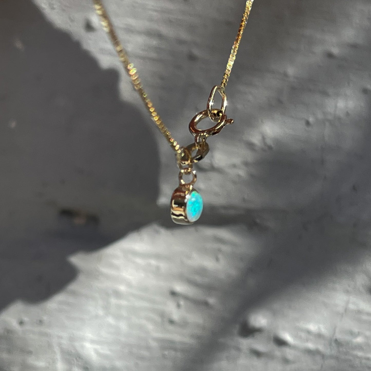 Side view of an Australian Opal Bracelet by NIXIN Jewelry. The dainty gold bracelet is made in 14k gold with a green opal.