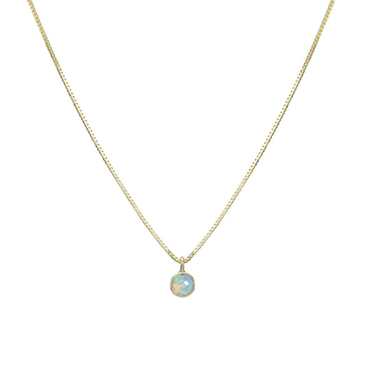 An Australian Opal Necklace by NIXIN Jewelry hangs in front of a white backdrop. The opal necklace pendant is made in 14k yellow gold with a Crystal Opal.