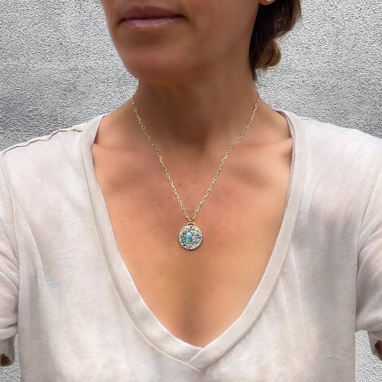 Model wearing n Australian Opal Necklace by NIXIN Jewelry combining a natural opal and sapphire layout to form a unique opal jewelry design. The blend of luxury and color creates a statement piece of jewelry art.