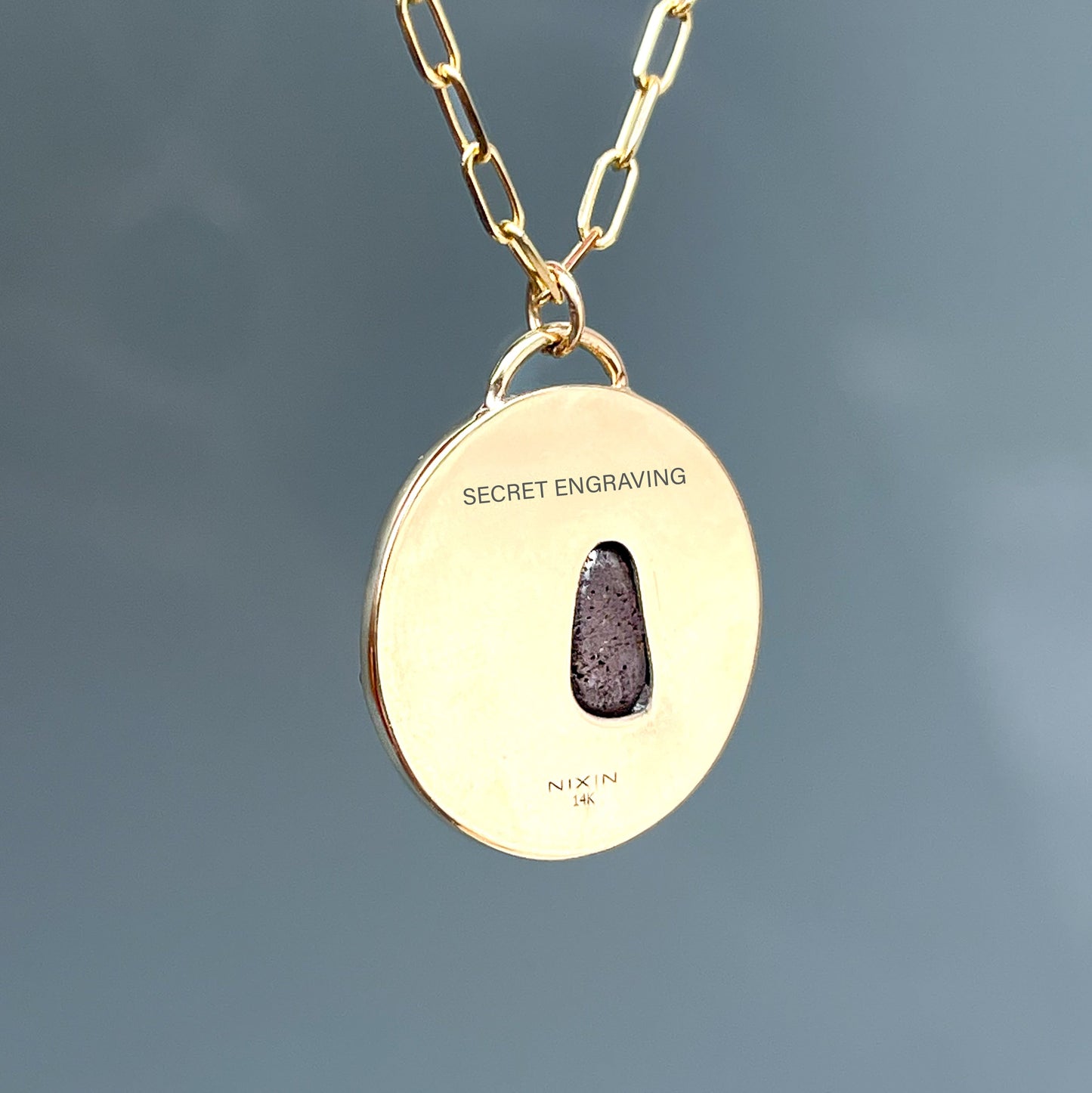 Gold back of an Australian Opal Necklace by NIXIN Jewelry with a bezel-set opal pendant encircled by blue, green, and teal sapphires. This unique opal necklace is a standout in women’s luxury necklace collections.