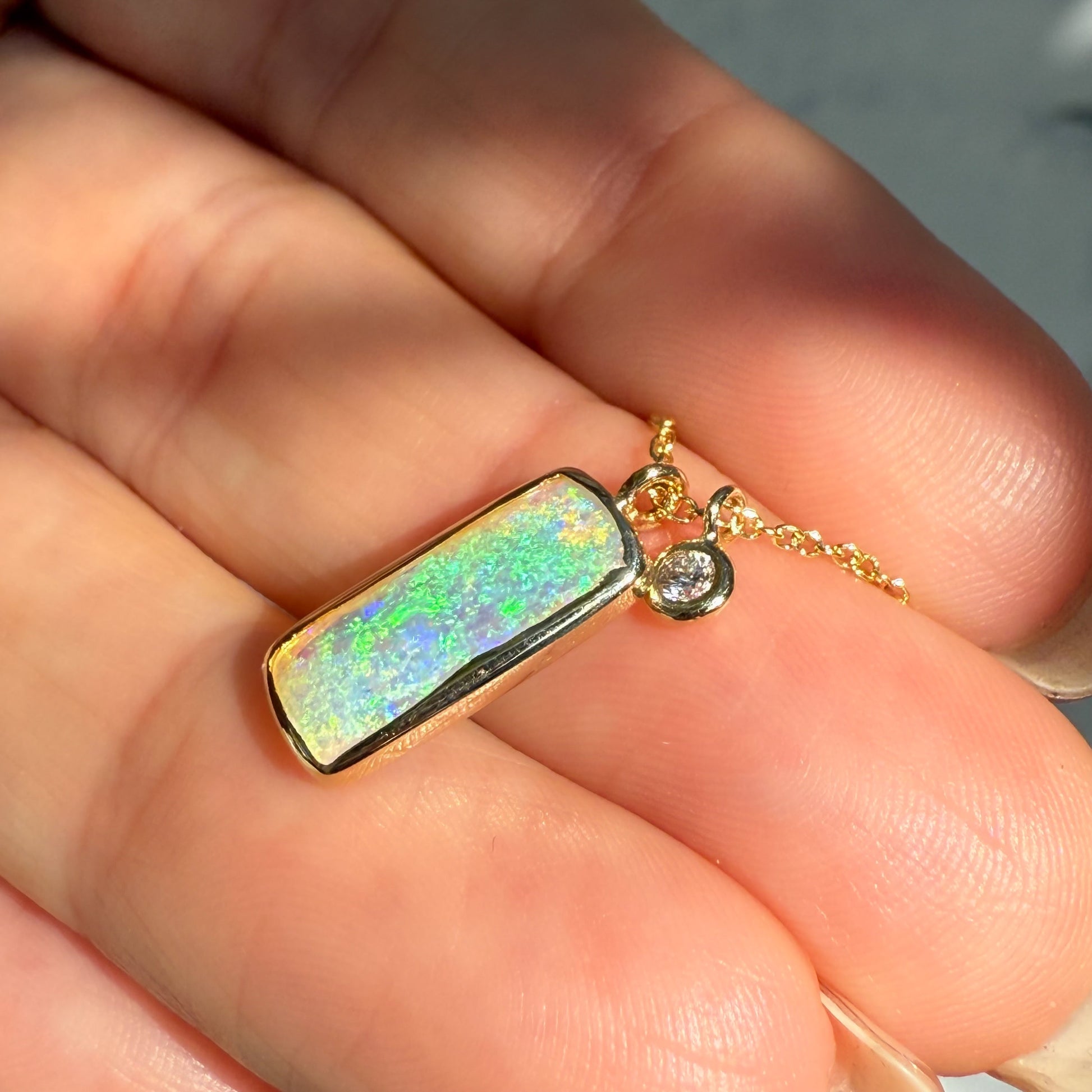 An Australian Opal Necklace by NIXIN Jewelry. The gold opal necklace is a piece of luxury jewelry combining a unique opal with a bezel-set diamond. This elegant opal necklace represents a fusion of art and luxury.