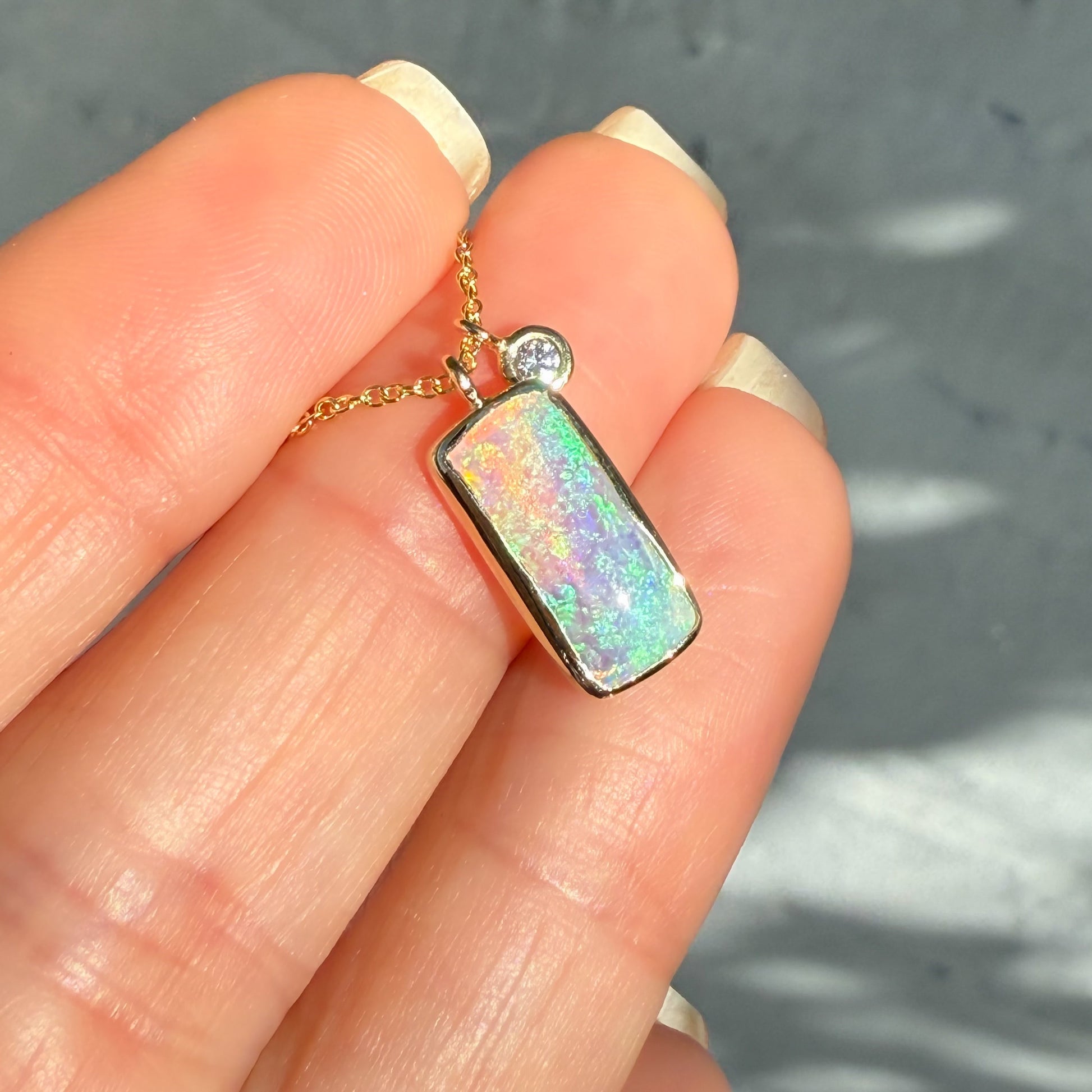 An Australian Opal Necklace by NIXIN Jewelry. A beautiful example of luxury jewelry and jewelry art, showcasing a rare opal stone. This unique opal necklace features a natural opal and a sparkling diamond accent.