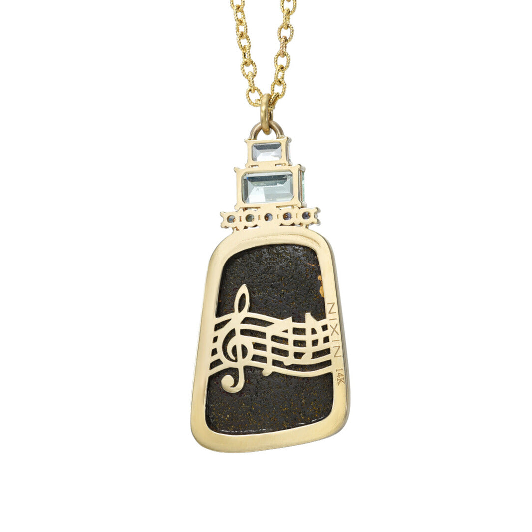 The back of an Australian Opal Necklace by NIXIN Jewelry showing 14k gold musical notes. Necklace shown against white backdrop.