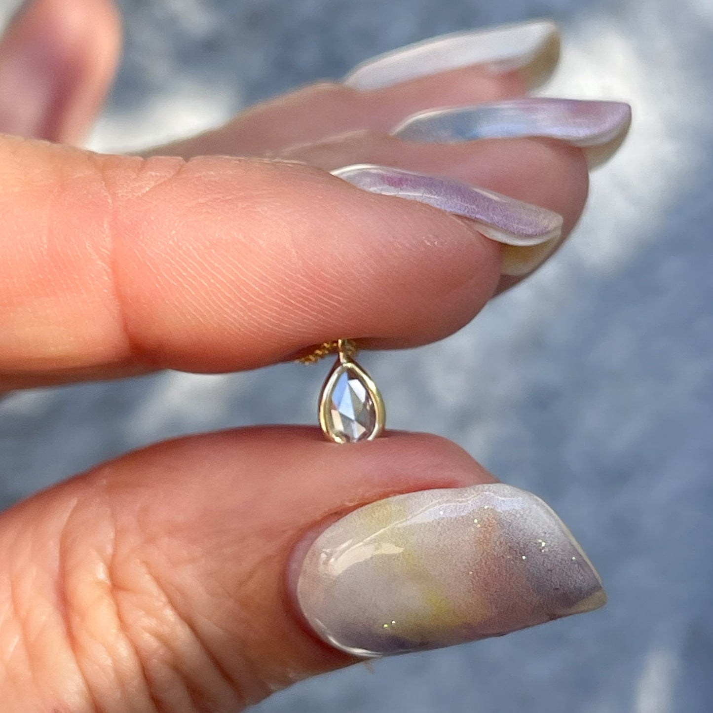 A Dainty Diamond Necklace by NIXIN Jewelry with a rose cut diamond in a pear shape.