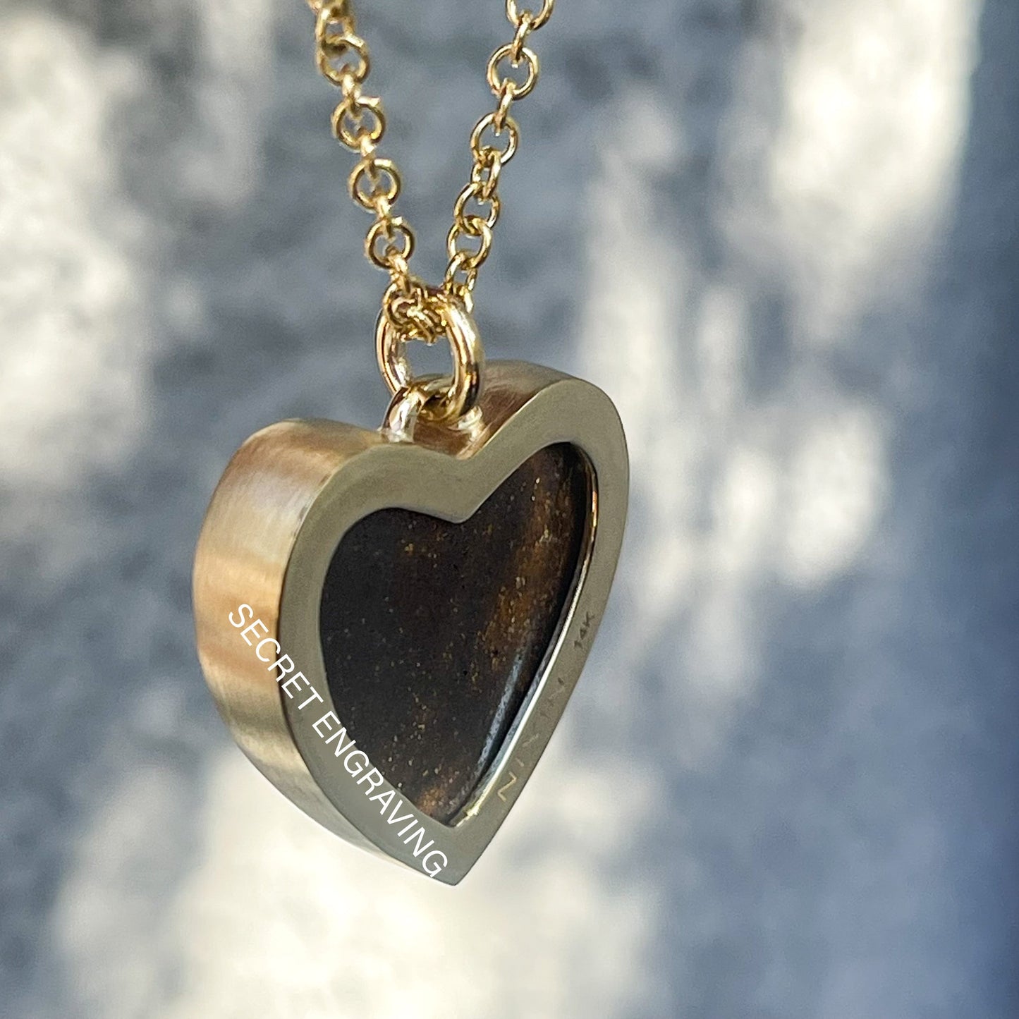 Back of an Australian Opal Necklace by NIXIN Jewelry showing the gold bezel and location of engraving.