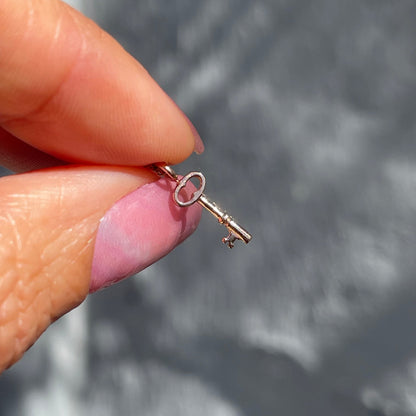 A rose gold key charm from an Australian Opal Necklace by NIXIN Jewelry.