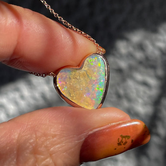 An Australian Opal Necklace by NIXIN Jewelry with an opal heart in a bezel setting.