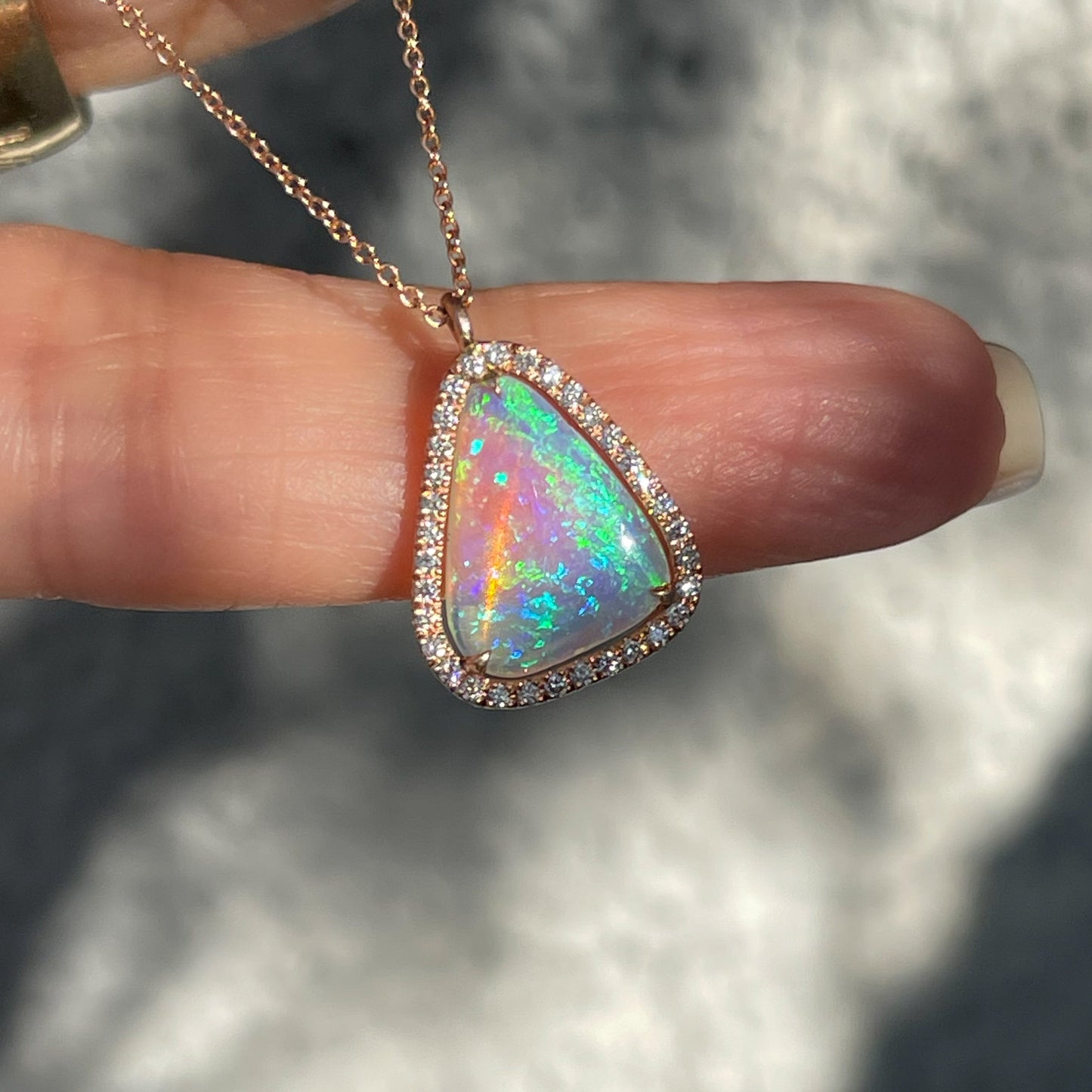 An Australian Opal Necklace by NIXIN Jewelry. An opal pendant with a diamond halo.