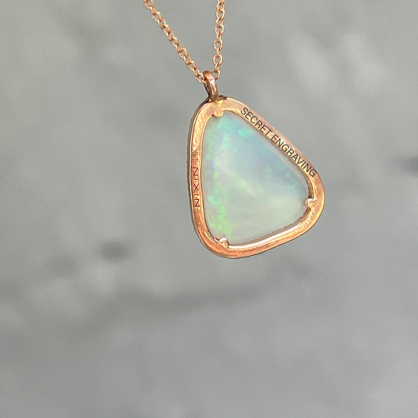 View of the back of an Australian Opal Necklace by NIXIN Jewelry. Shows the location of the secret engraving.