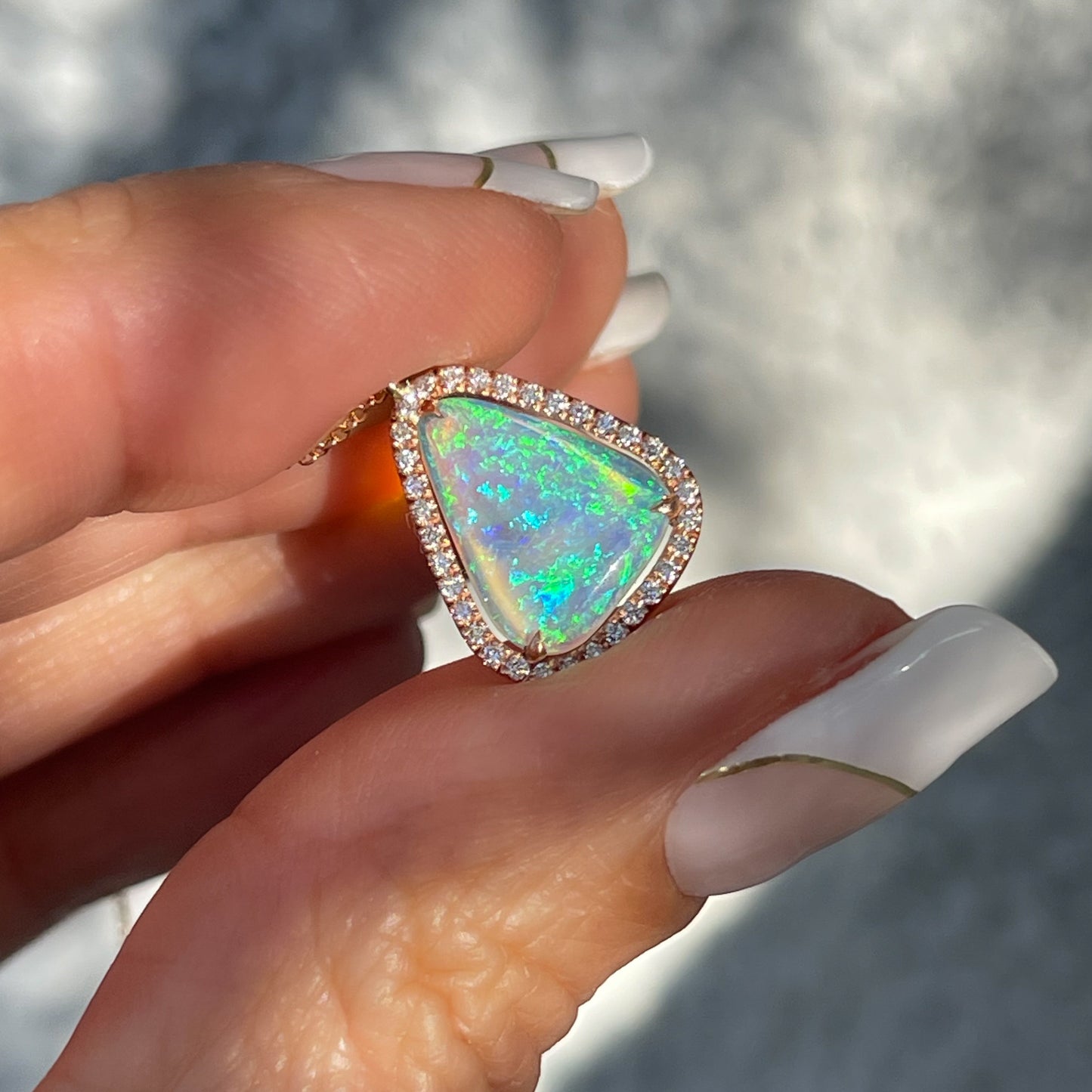 An Australian Opal Necklace by NIXIN Jewelry. An opal pendant with a diamond halo.
