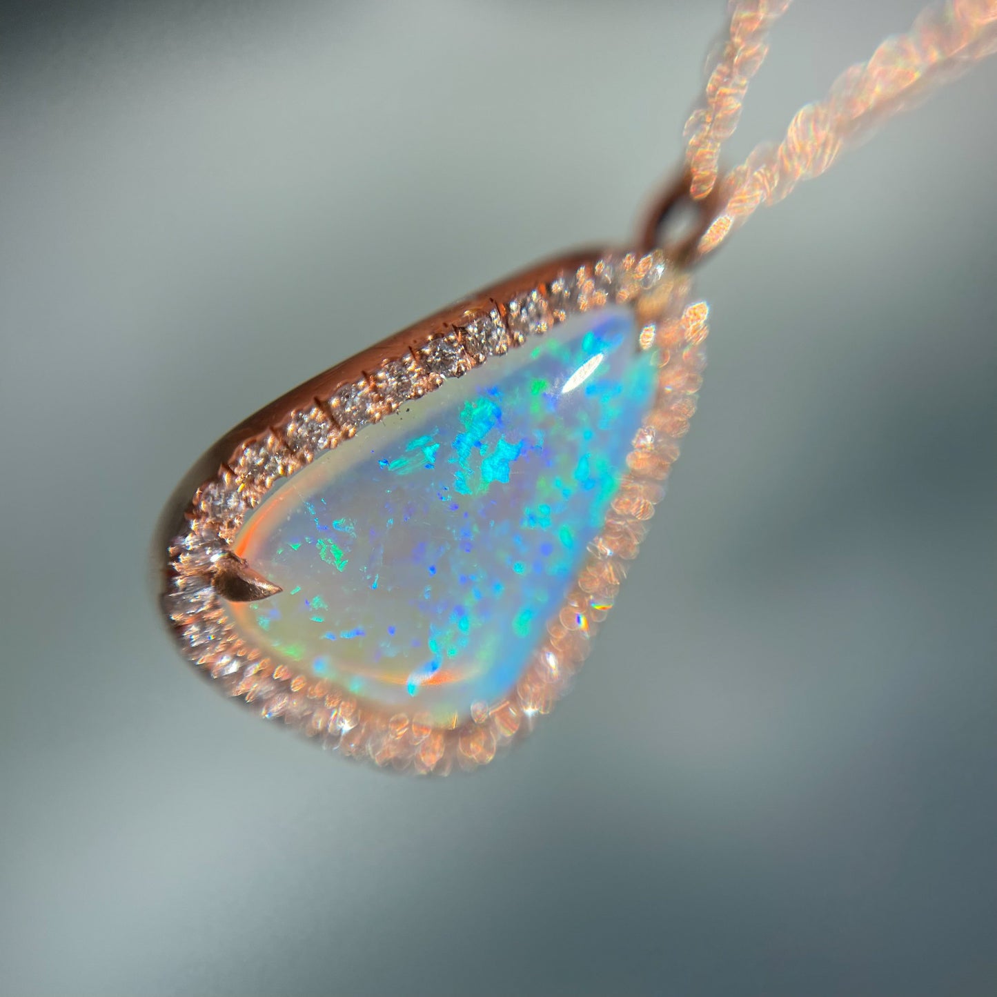 Close up of an Australian Opal Necklace by NIXIN Jewelry. Shows the rose gold setting and the Crystal Opal with pave diamonds.