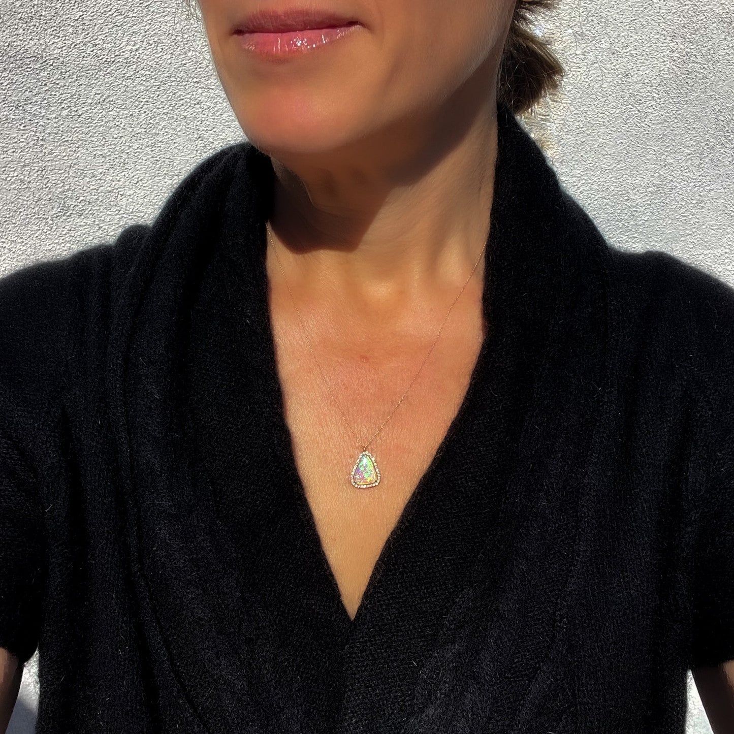 Model wearing an Australian Opal Necklace by NIXIN Jewelry. The unique jewelry is made in rose gold.