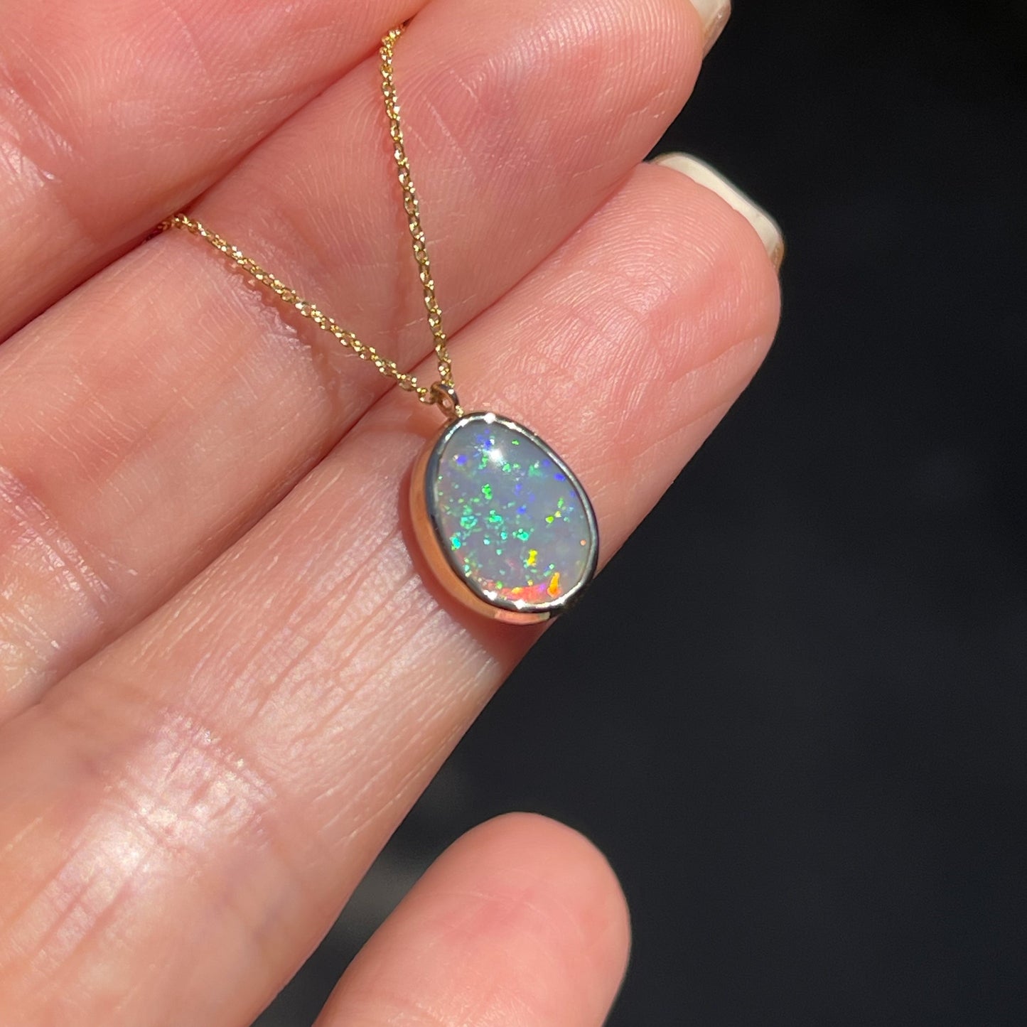 Angled shot of an Australian Opal Necklace by NIXIN Jewelry. Shows the wall of the bezel setting.