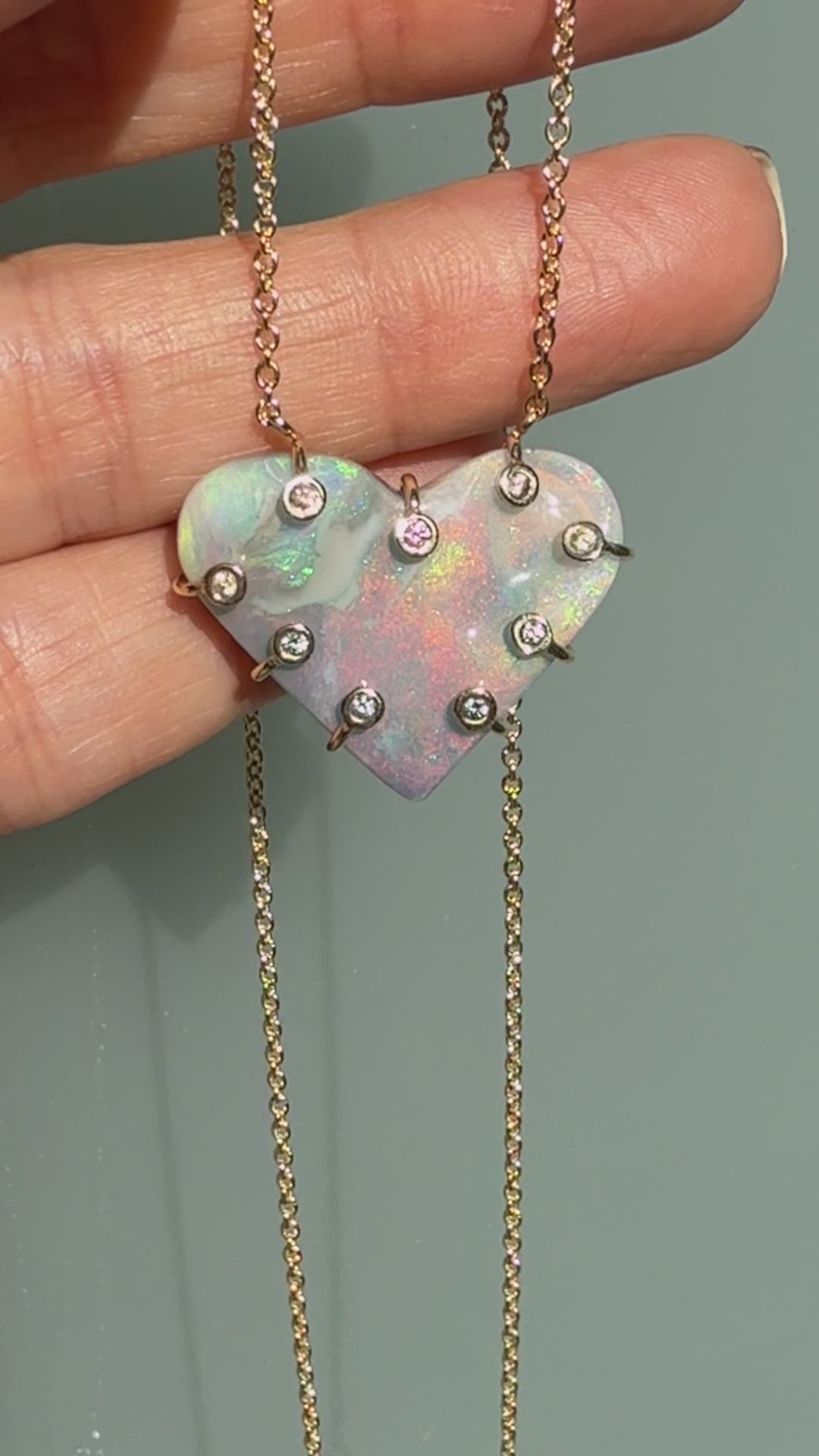 An Australian Opal Necklace by NIXIN Jewelry video demonstrating the intense opal fire in the semi black opal heart pendant. The movement highlights the unique light diffraction and the security of the sapphires in the prong setting. This rare opal jewelry video is a true display of jewelry art.