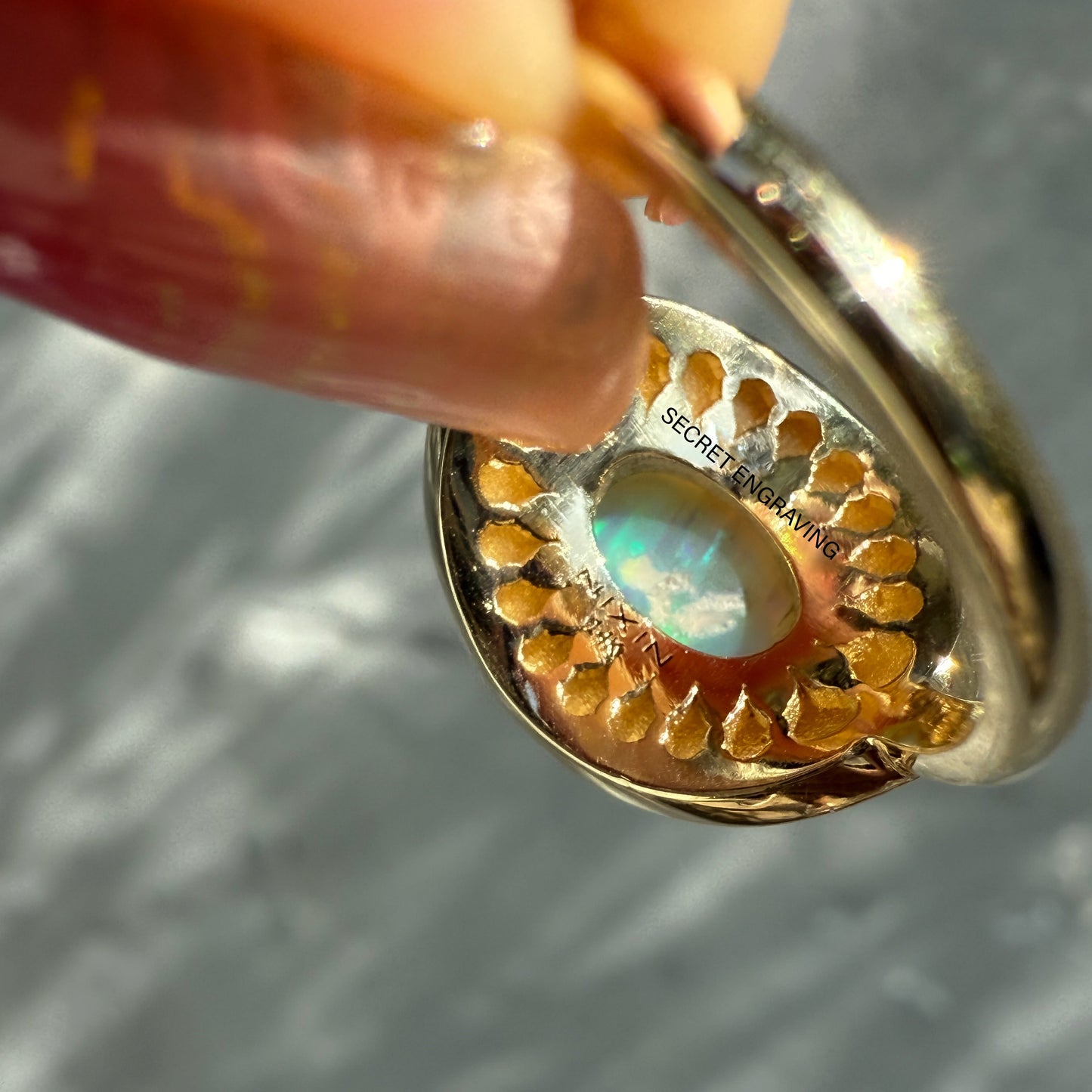 An Australian Opal Ring by NIXIN Jewelry, featuring the underside of the band and its unique geometric gallery. This is a rare opal ring with a hidden secret engraving, making it a unique fine jewelry piece.