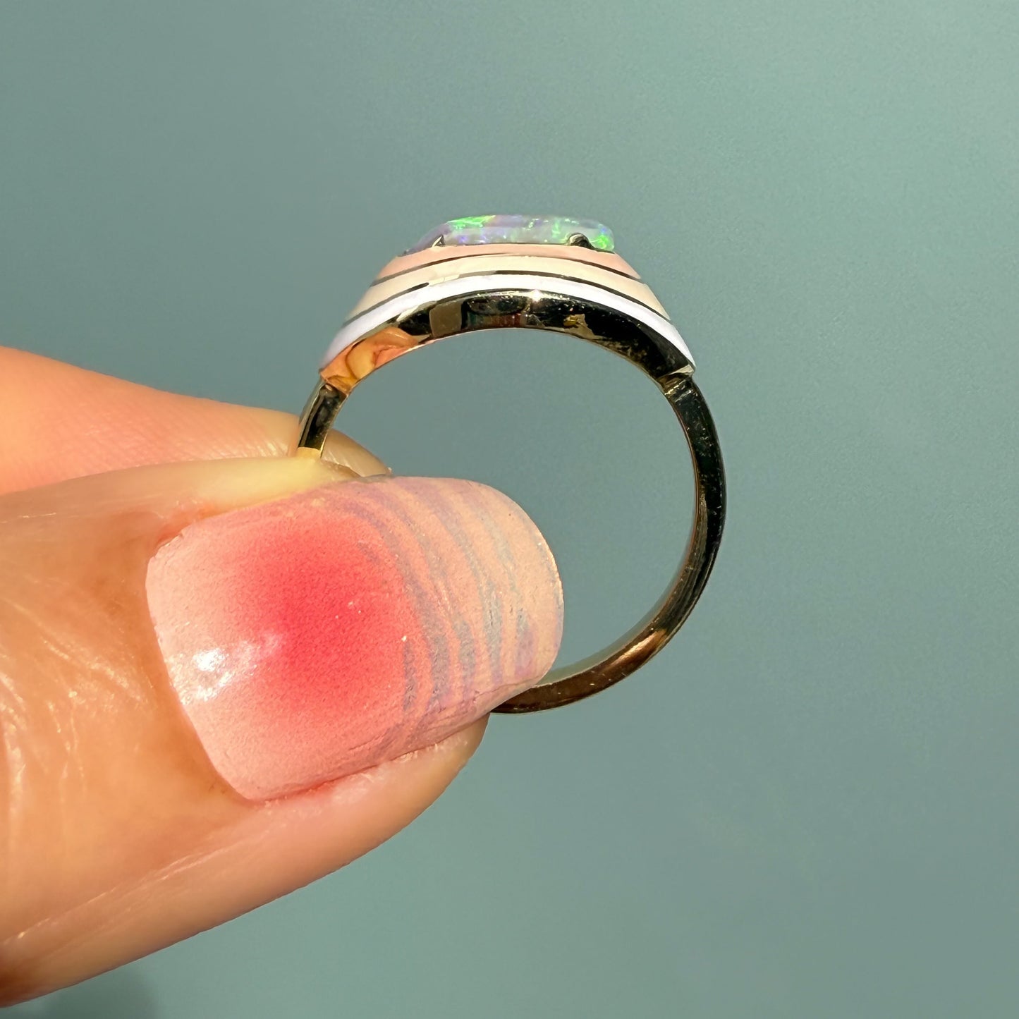 An Australian Opal Ring by NIXIN Jewelry, shown from a side profile with a three-tone enamel design. The modern opal ring features a central crystal opal, making it a piece of exceptional jewelry art.
