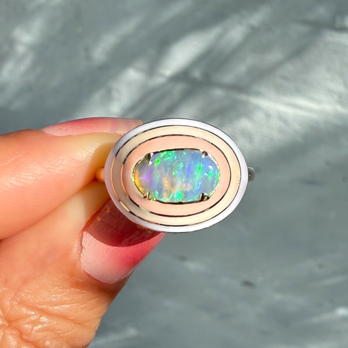An Australian Opal Ring by NIXIN Jewelry, with a mesmerizing crystal opal from Lightning Ridge. This unique fine jewelry piece features a rare opal ring design, perfectly captured in natural light on a gray background.