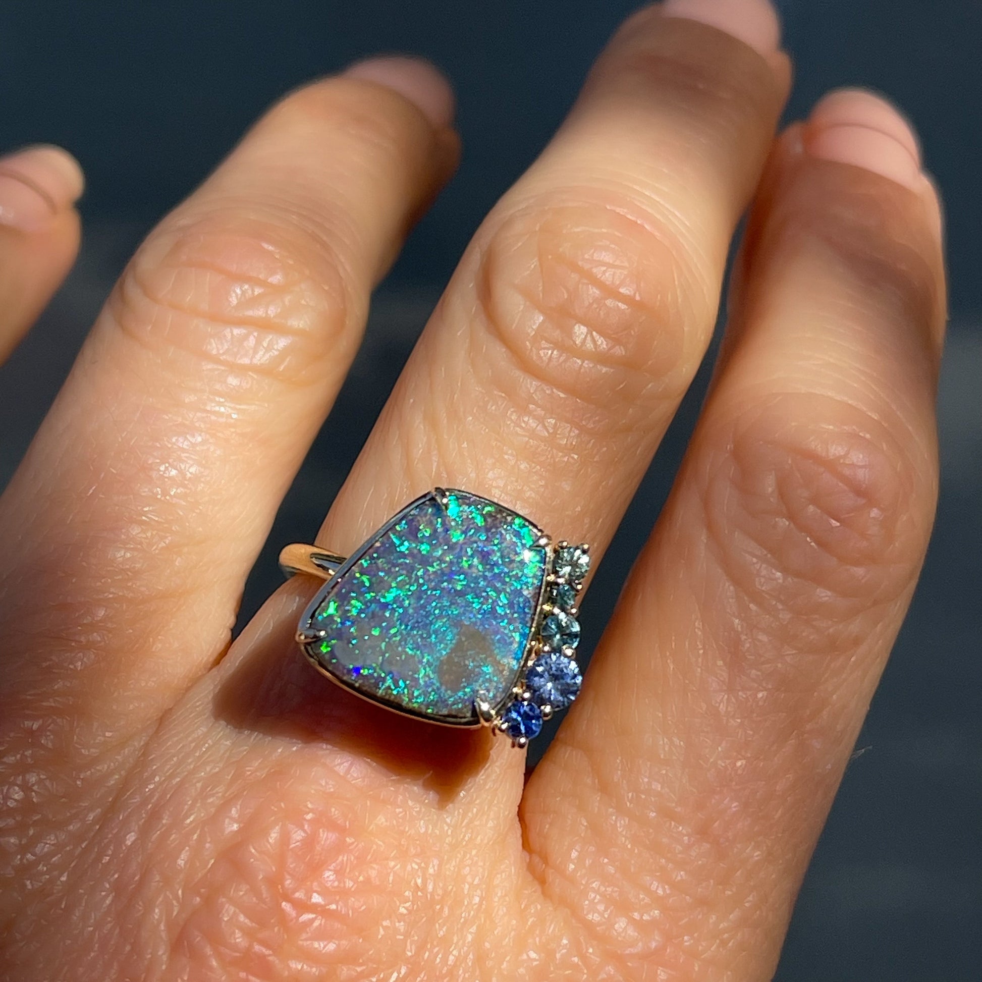 An Australian Opal Ring by NIXIN Jewelry with green and blue sapphires. The unique opal ring is jewelry art.