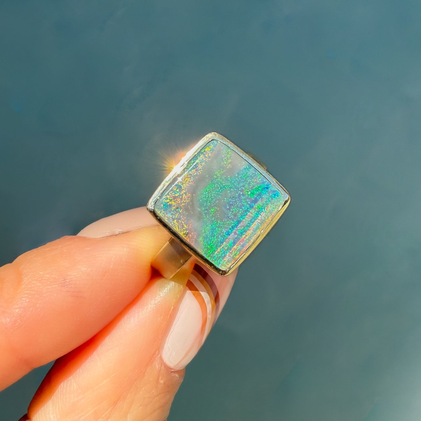 An Australian Opal Ring by NIXIN Jewelry, boasting a genuine Lightning Ridge opal. This rare jewelry item is a striking black opal ring with exceptional fire.