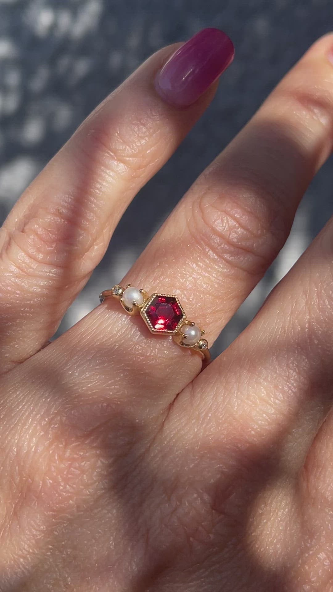 Video of gold garnet ring by NIXIN Jewelry worn on model's hand