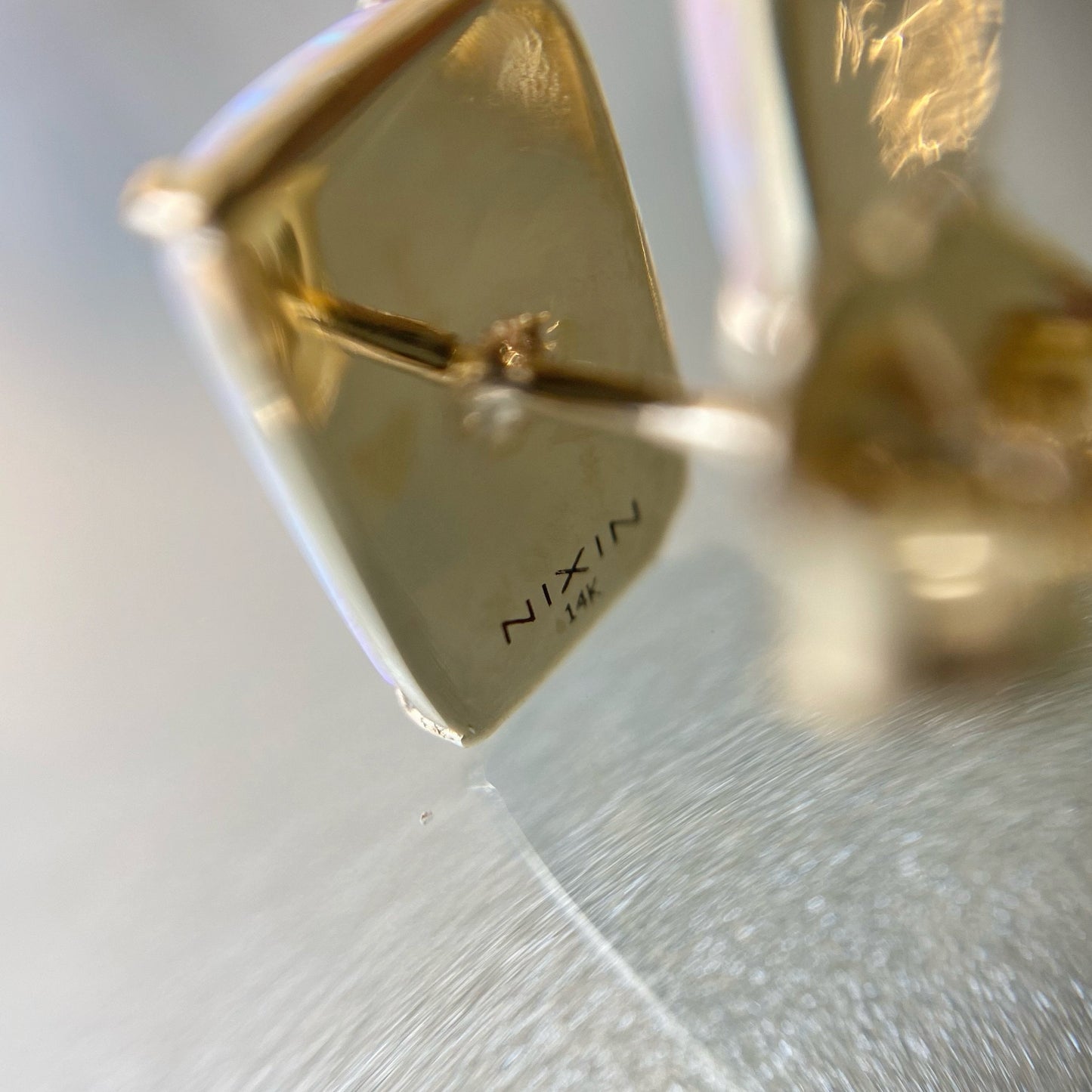 Close up of back of gold opal studs by NIXIN Jewelry