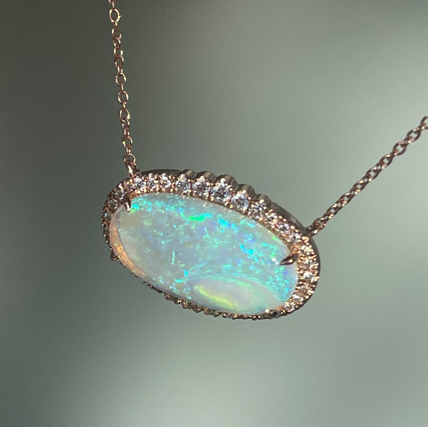 An Australian Opal Necklace by NIXIN Jewelry shown from above, looking down. Made in rose gold with a lavender and blue opal.