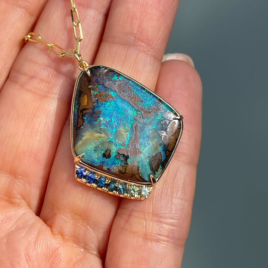 Australian opal necklace by NIXIN Jewelry atop hand