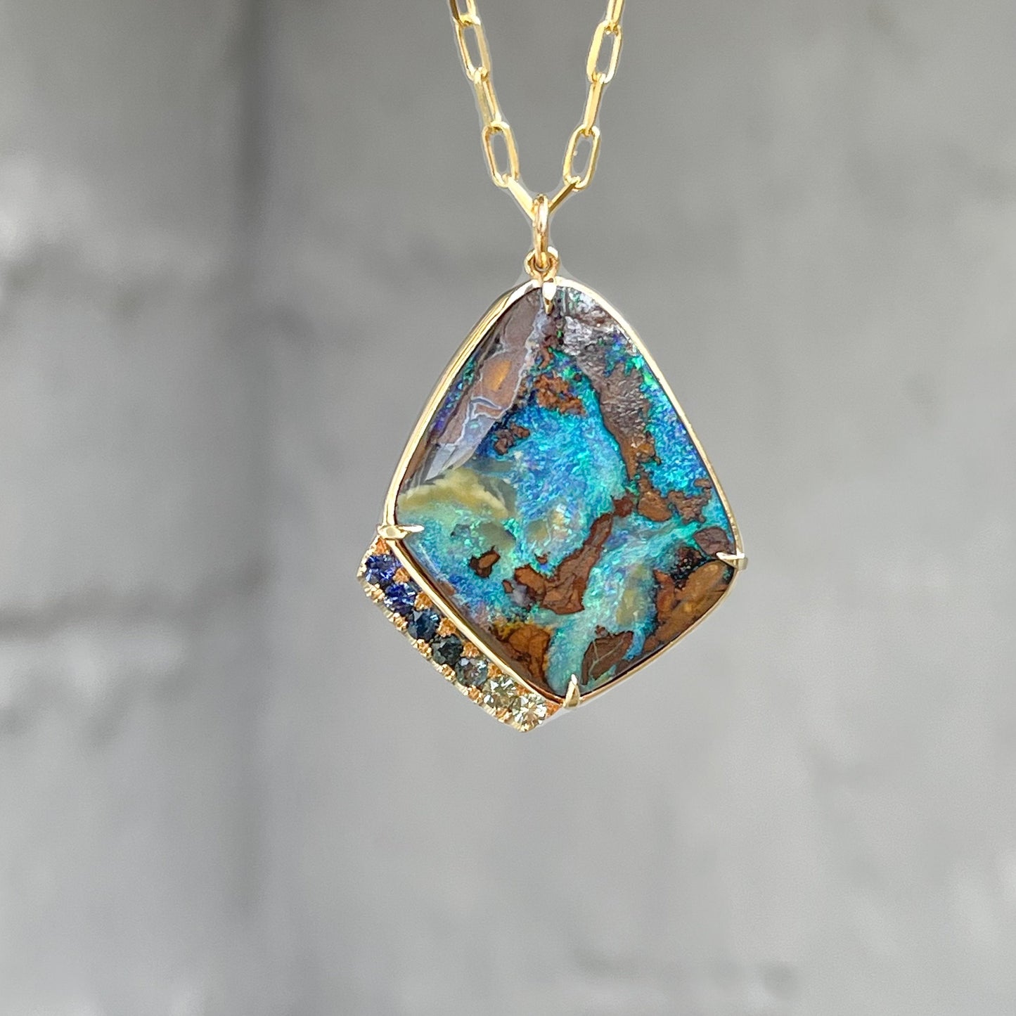 Blue green opal necklace by NIXIN Jewelry against grey backdrop