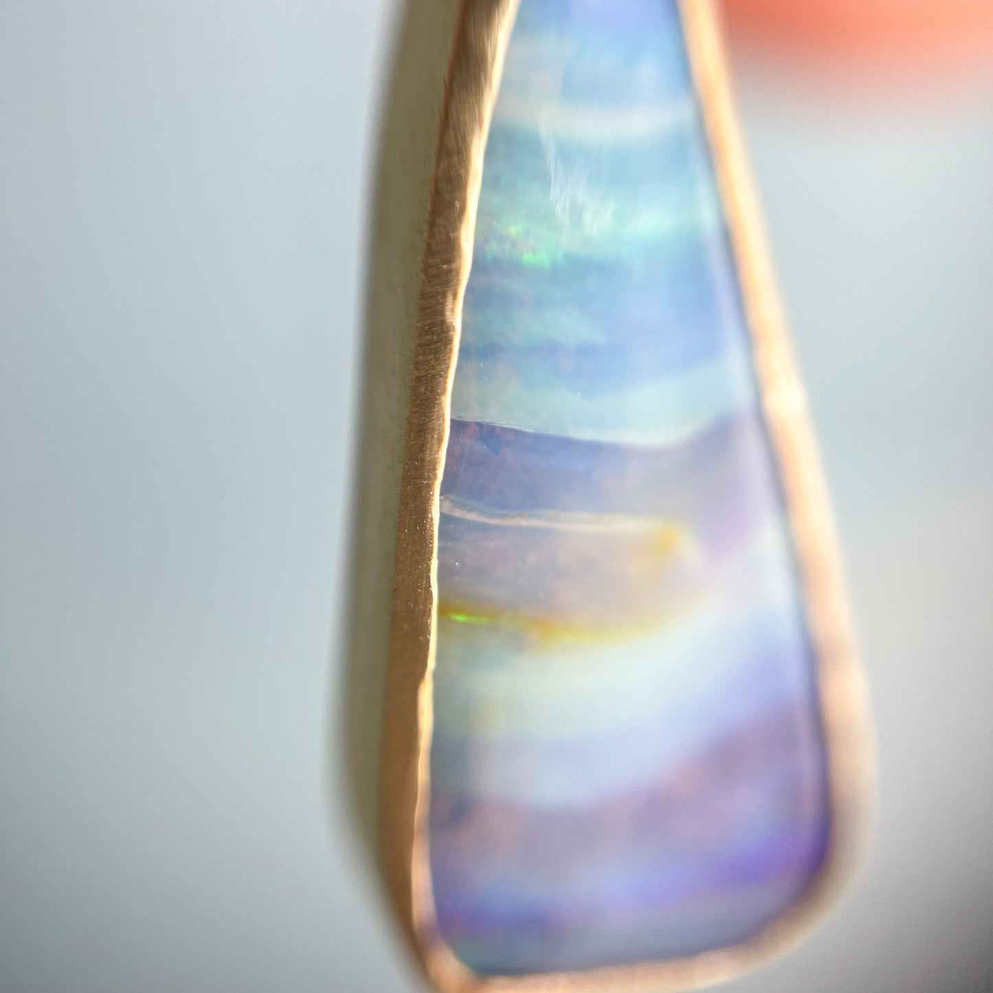 Gold opal necklace by NIXIN Jewelry shot under jewelers loupe