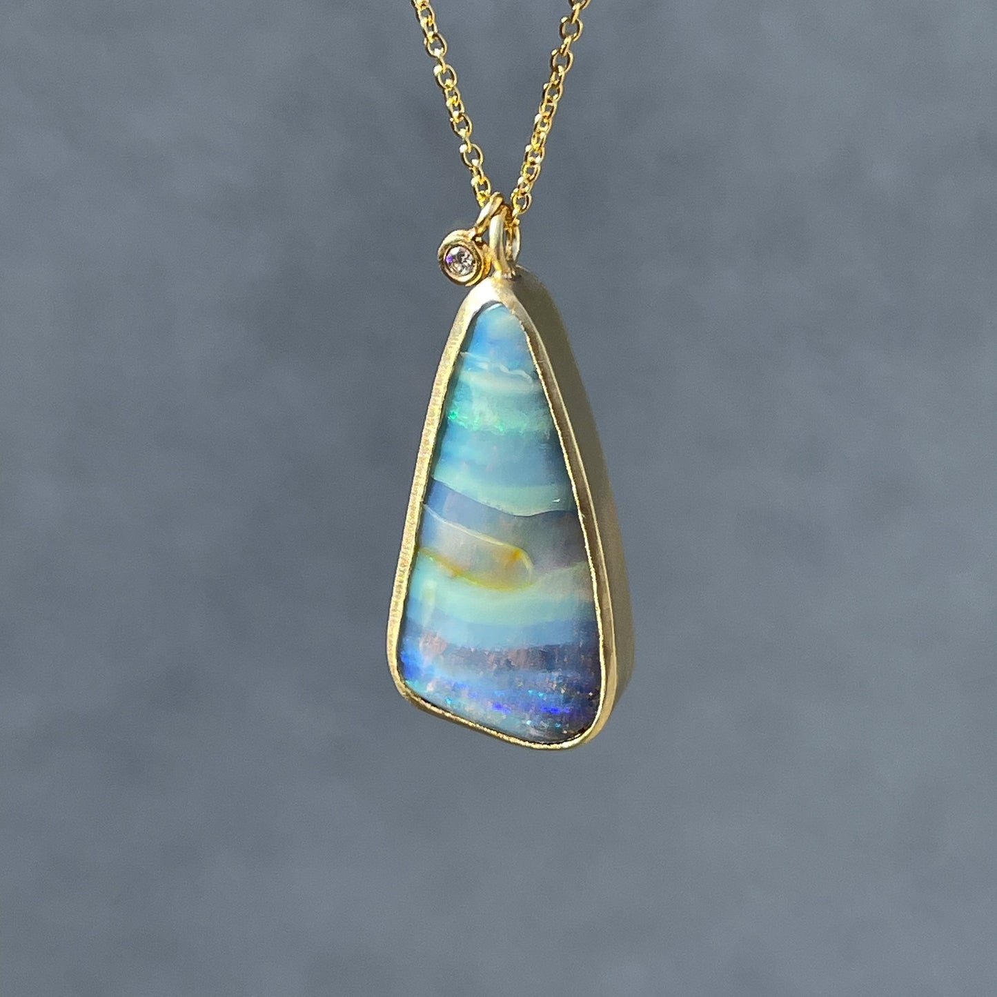 Opal and diamond necklace by NIXIN Jewelry suspended in sunlight