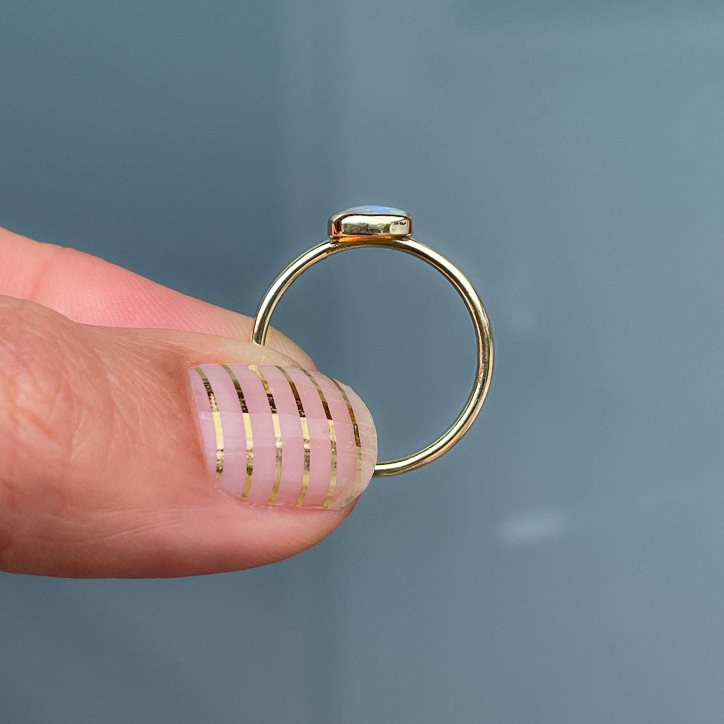 Profile view of dainty gold opal ring by NIXIN Jewelry