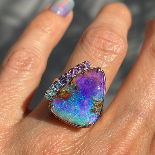 An Australian Opal Ring by NIXIN Jewelry features sapphires and opal in 14k rose gold.