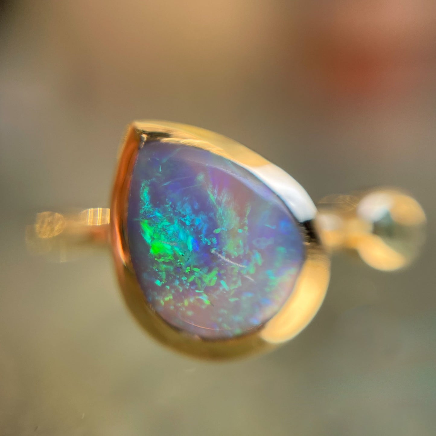 Close up of an Australian Opal Ring by NIXIN Jewelry. A gold opal ring with a pear shaped Black Opal.