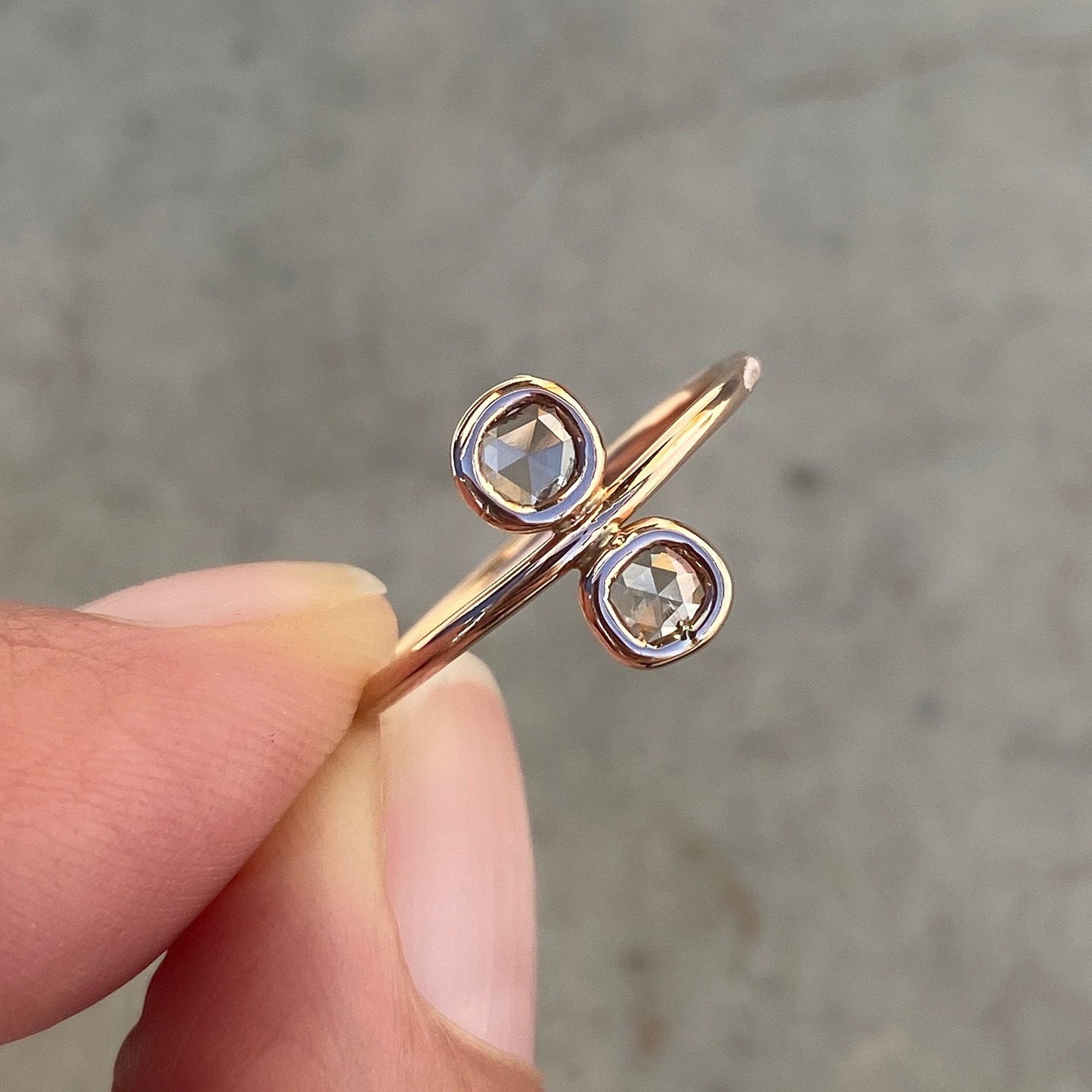 Paleo Double Diamond Slice Rose Gold Ring held between fingers