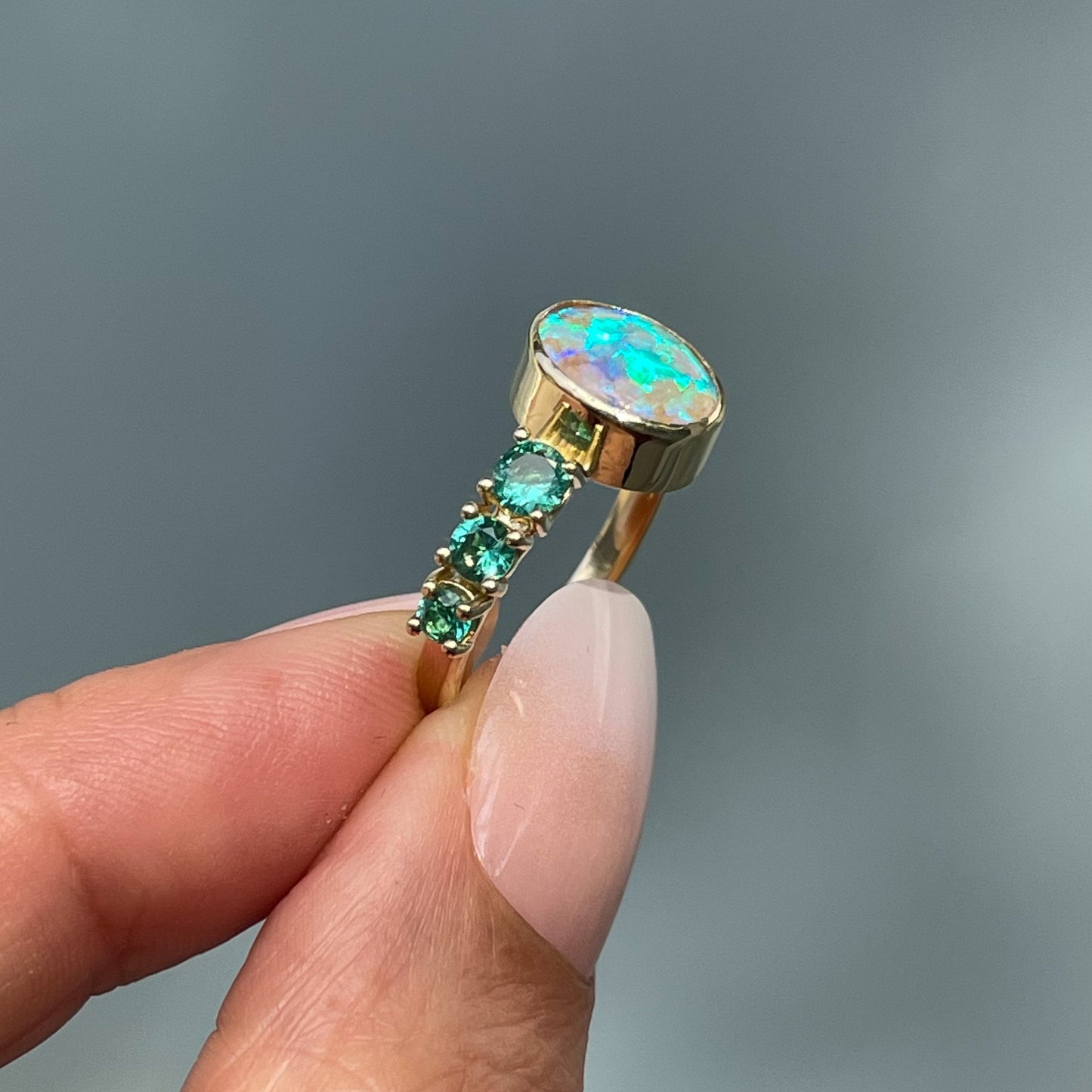 Australian opal ring by NIXIN Jewelry held in sunlight