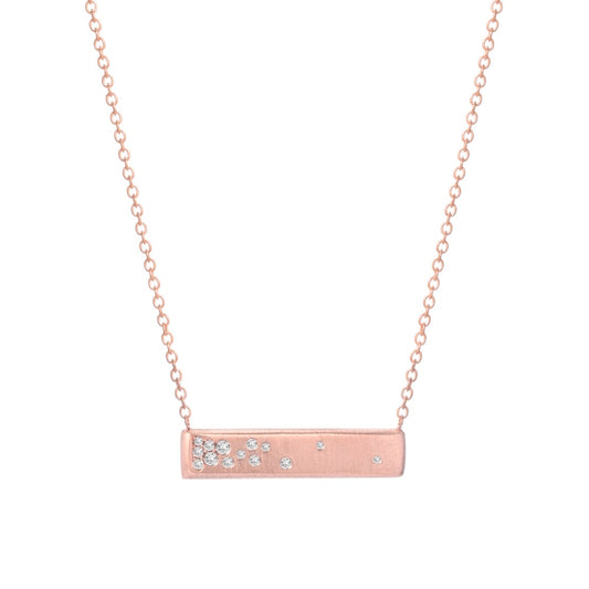 A rose gold bar necklace with matte finish and flush set diamonds by line + hue.