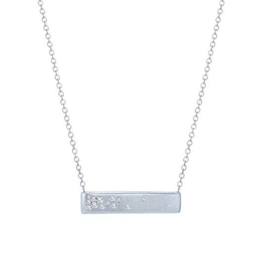 A white gold bar necklace with matte finish and flush set diamonds by line + hue.