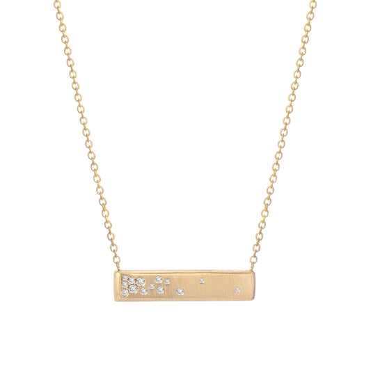 A gold bar necklace with matte finish and flush set diamonds by line + hue.