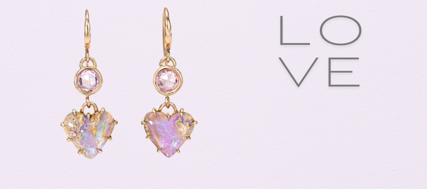 Australian Opal Earrings by NIXIN Jewelry in front of a purple background. The drop earrings are set in rose gold with purple sapphires.