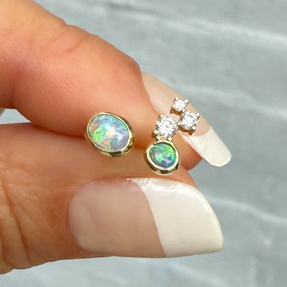 Australian Opal Earrings by NIXIN Jewelry. Mismatched opal stud earrings showcasing two unique black crystal opal stones. The larger opal stone flashes rare lavender, green, and peach hues, offering unique jewelry in a modern opal jewelry design.