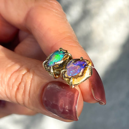 Angled view of a pair of Australian Opal Earrings by NIXIN Jewelry. One of a kind pipe boulder opal earrings.