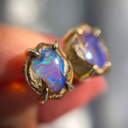 Magnified view of a pair of Australian Opal Earrings by NIXIN Jewelry. The opal stud earrings are a form of jewelry art.